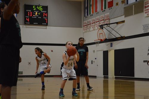 student shooting basketball